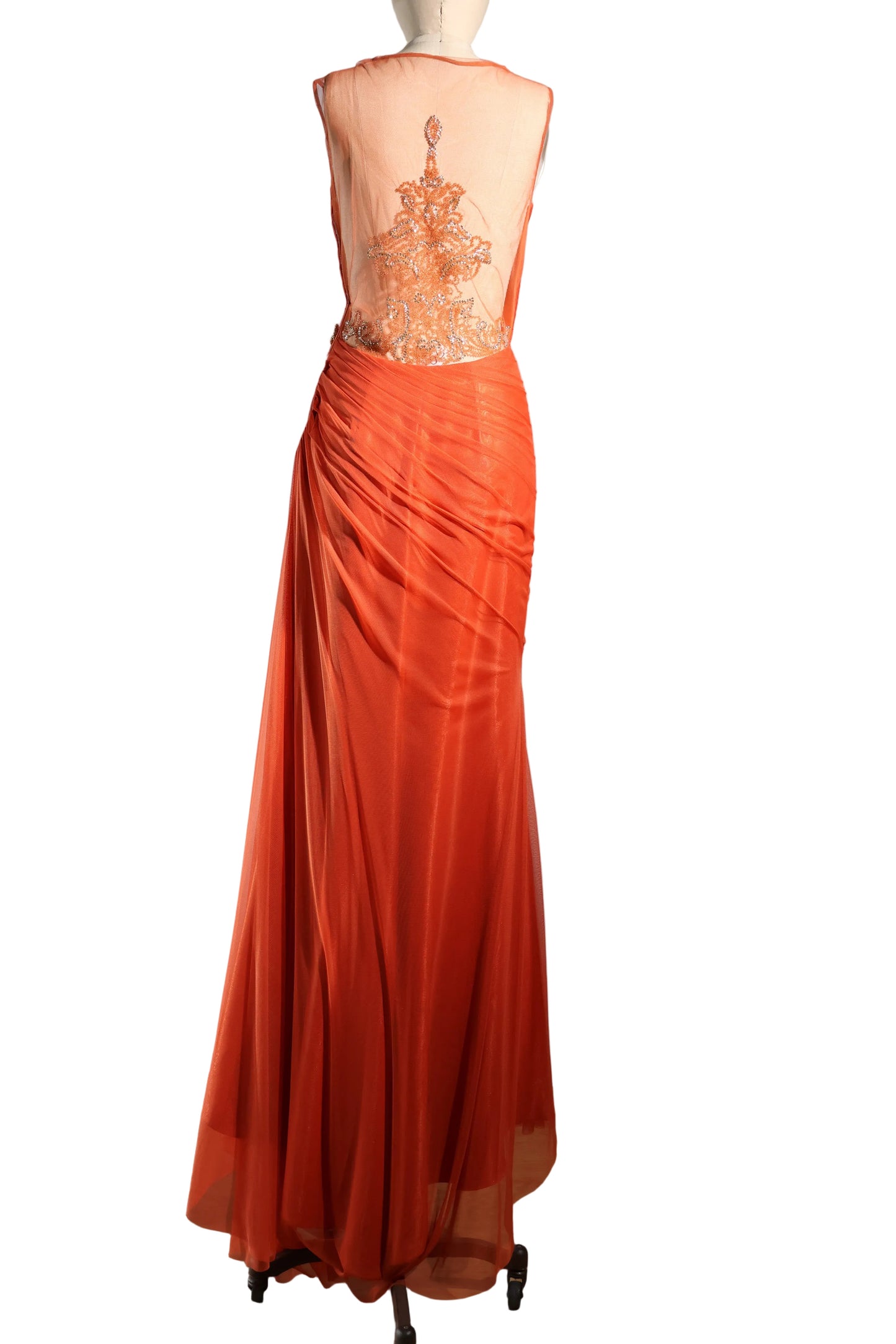 Orange evening gown with intricate back design on a mannequin against a plain background
