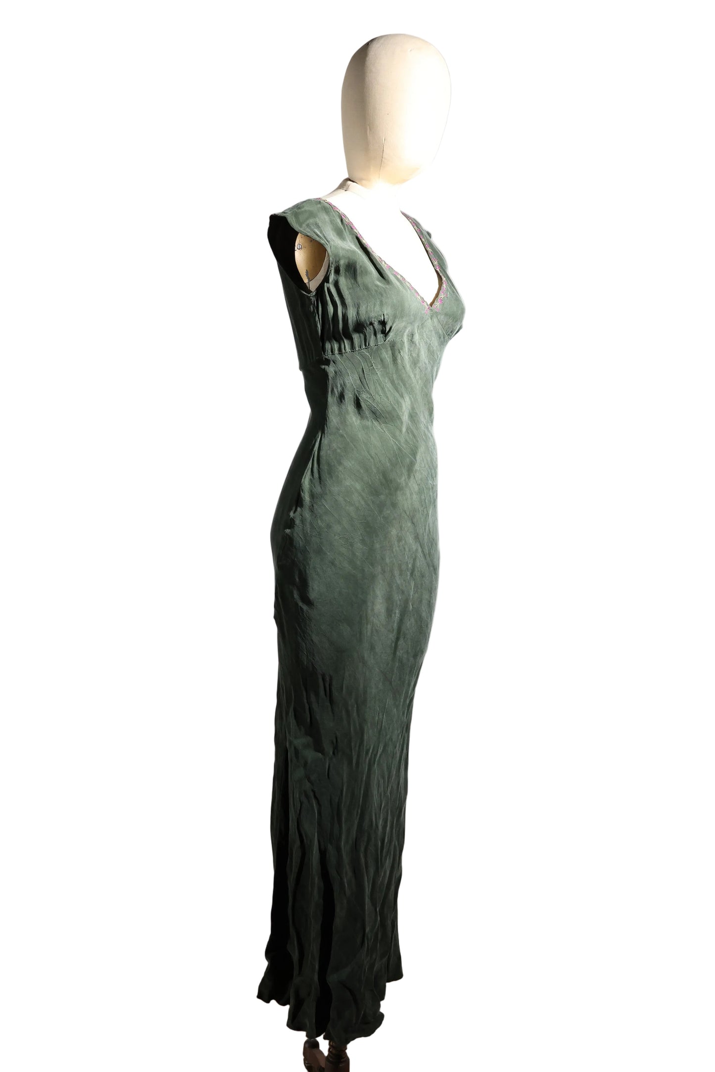 Green dress on a mannequin against a white background