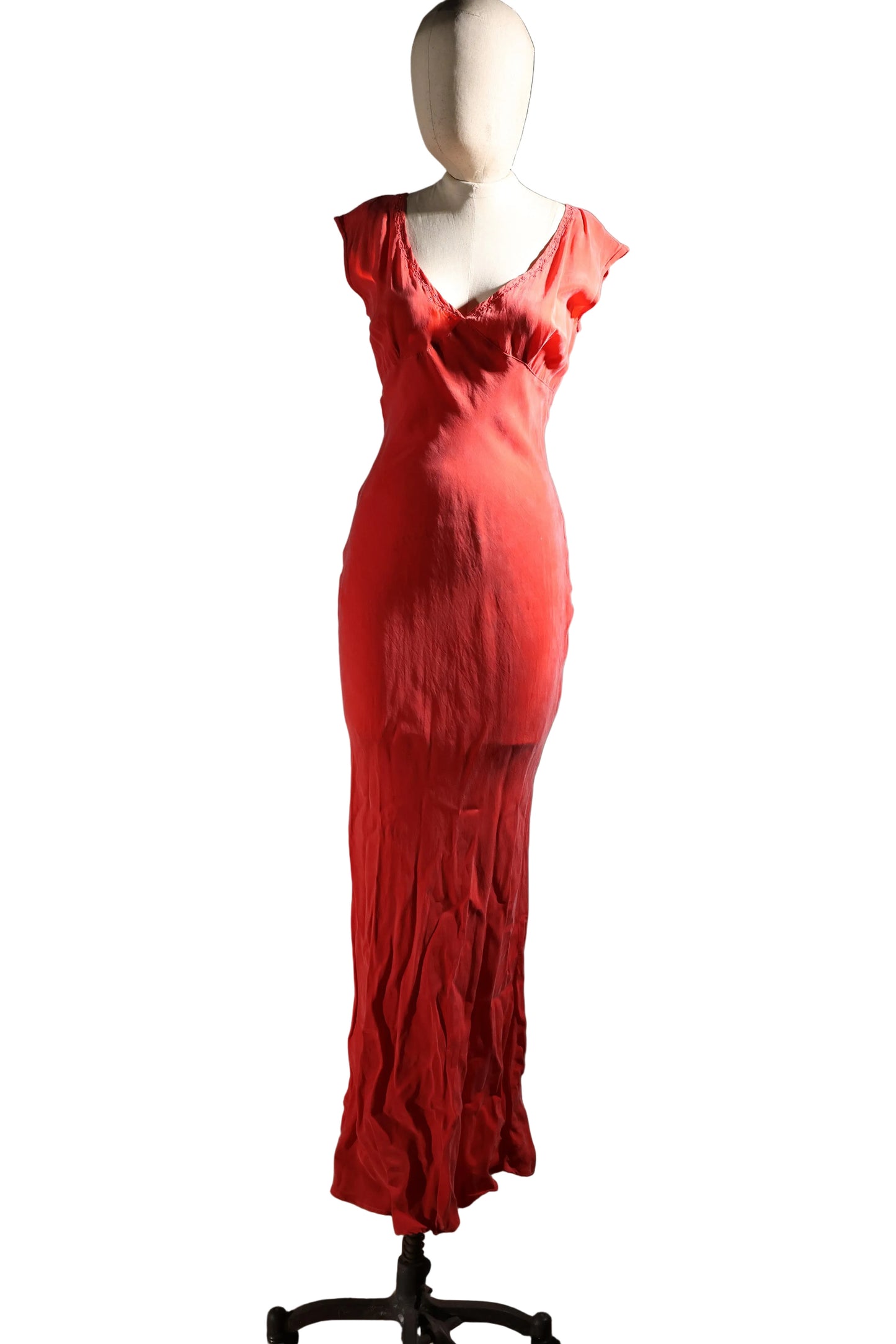 Red evening gown on a mannequin against a plain wall.