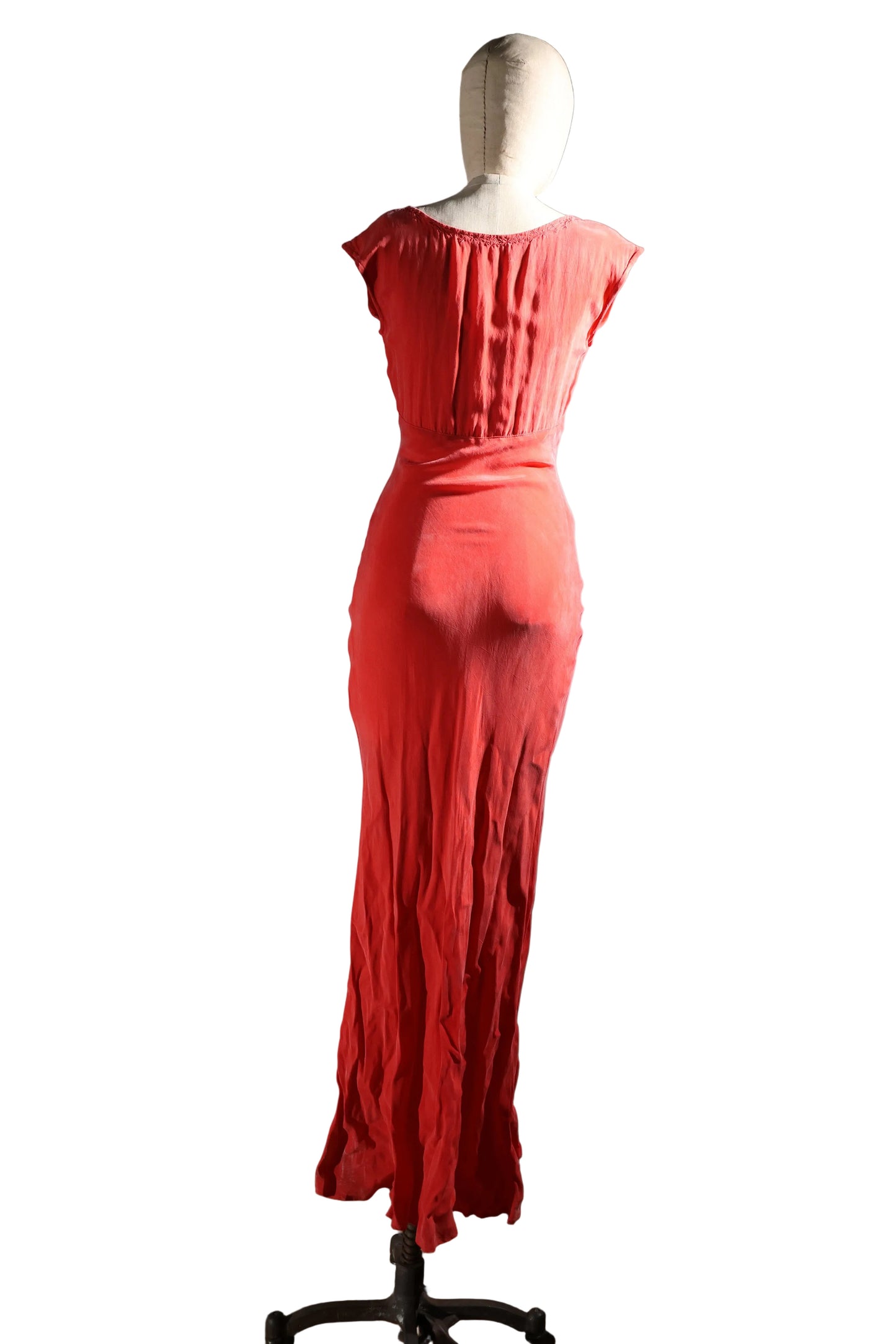 Red dress on a mannequin against a plain wall