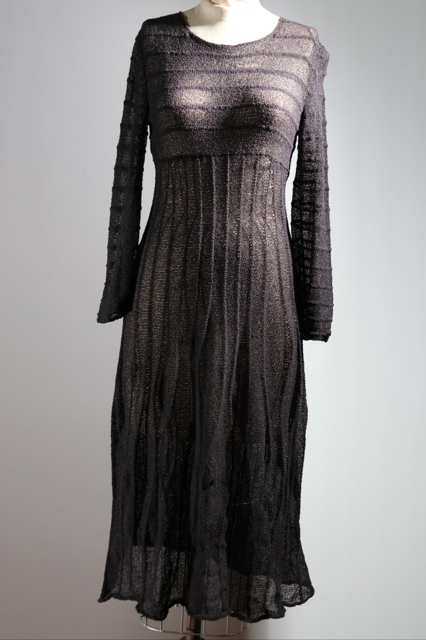 Black lace dress on a mannequin against a gray background