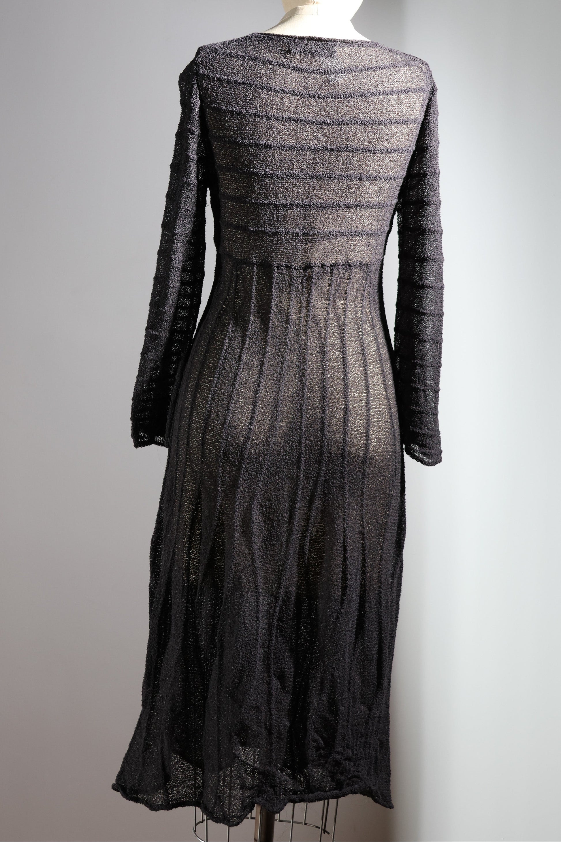 Dark gray dress on a mannequin against a plain background