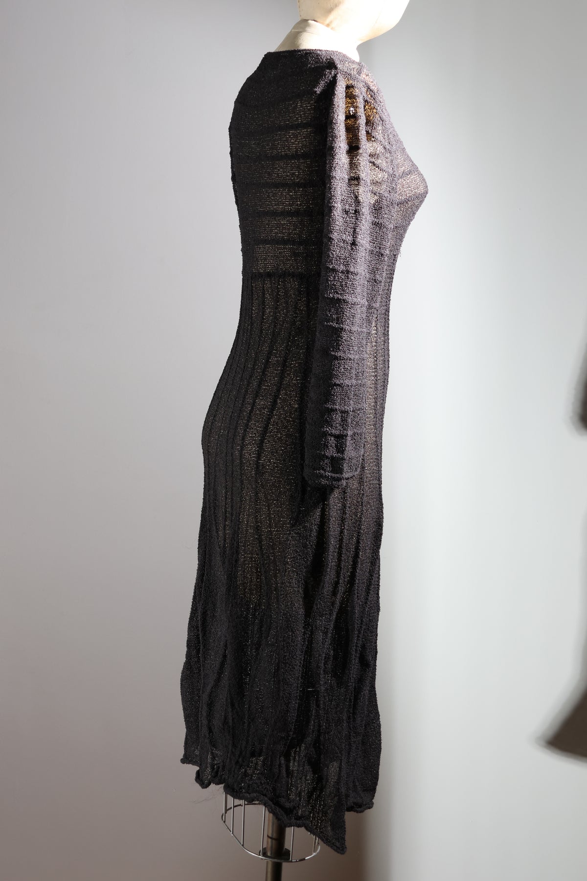 Dark gray dress on a mannequin against a plain background