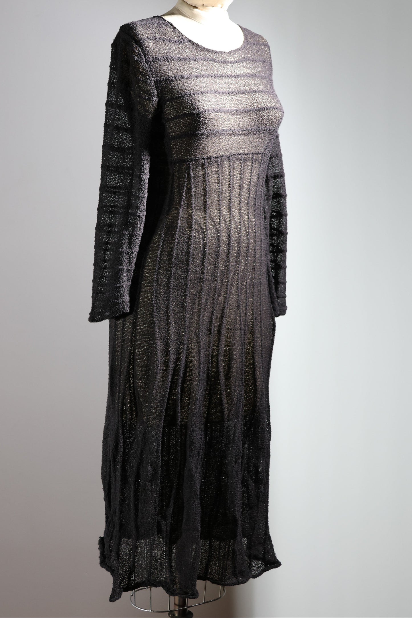 Black lace dress on a mannequin against a gray background