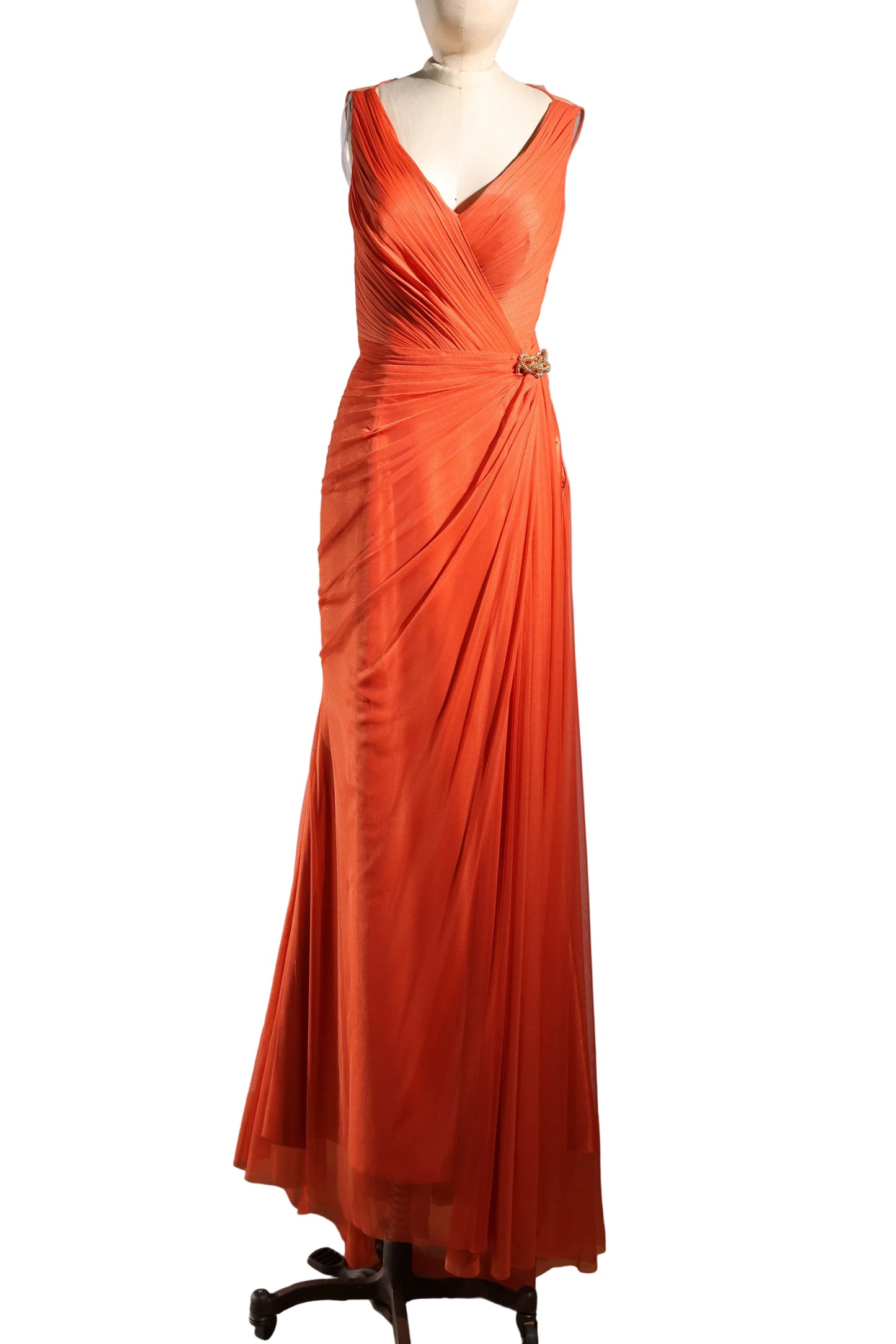 Orange evening gown on a mannequin against a plain background