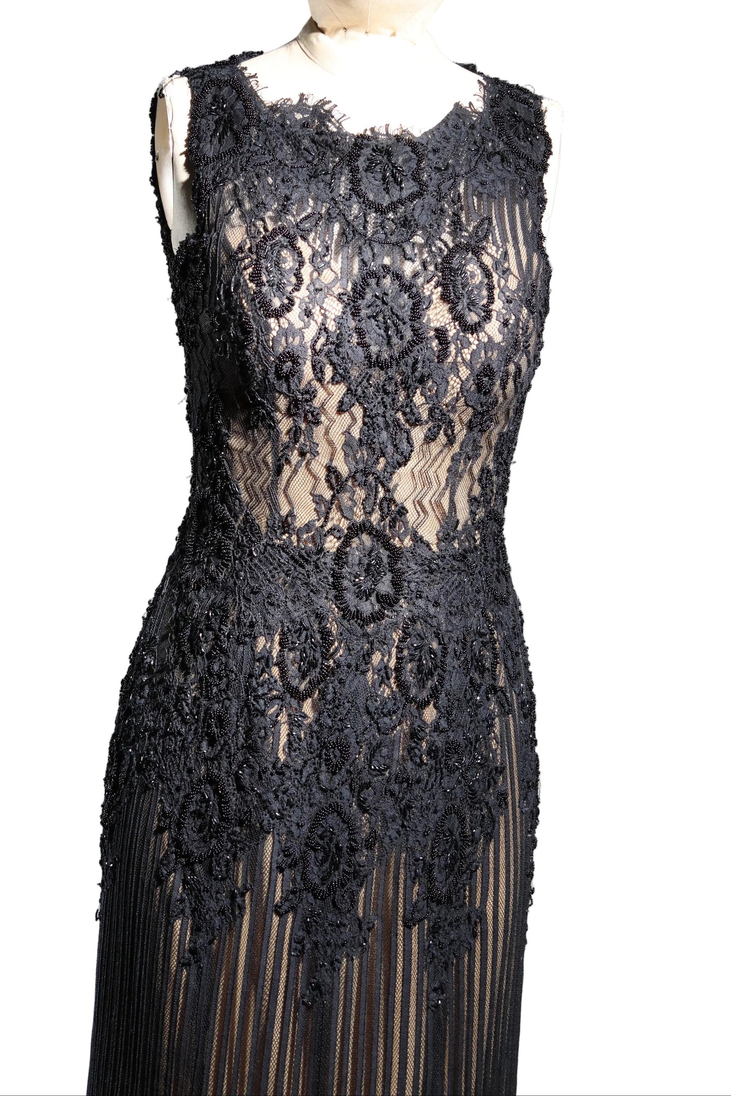 Black lace dress on a mannequin against a gray background