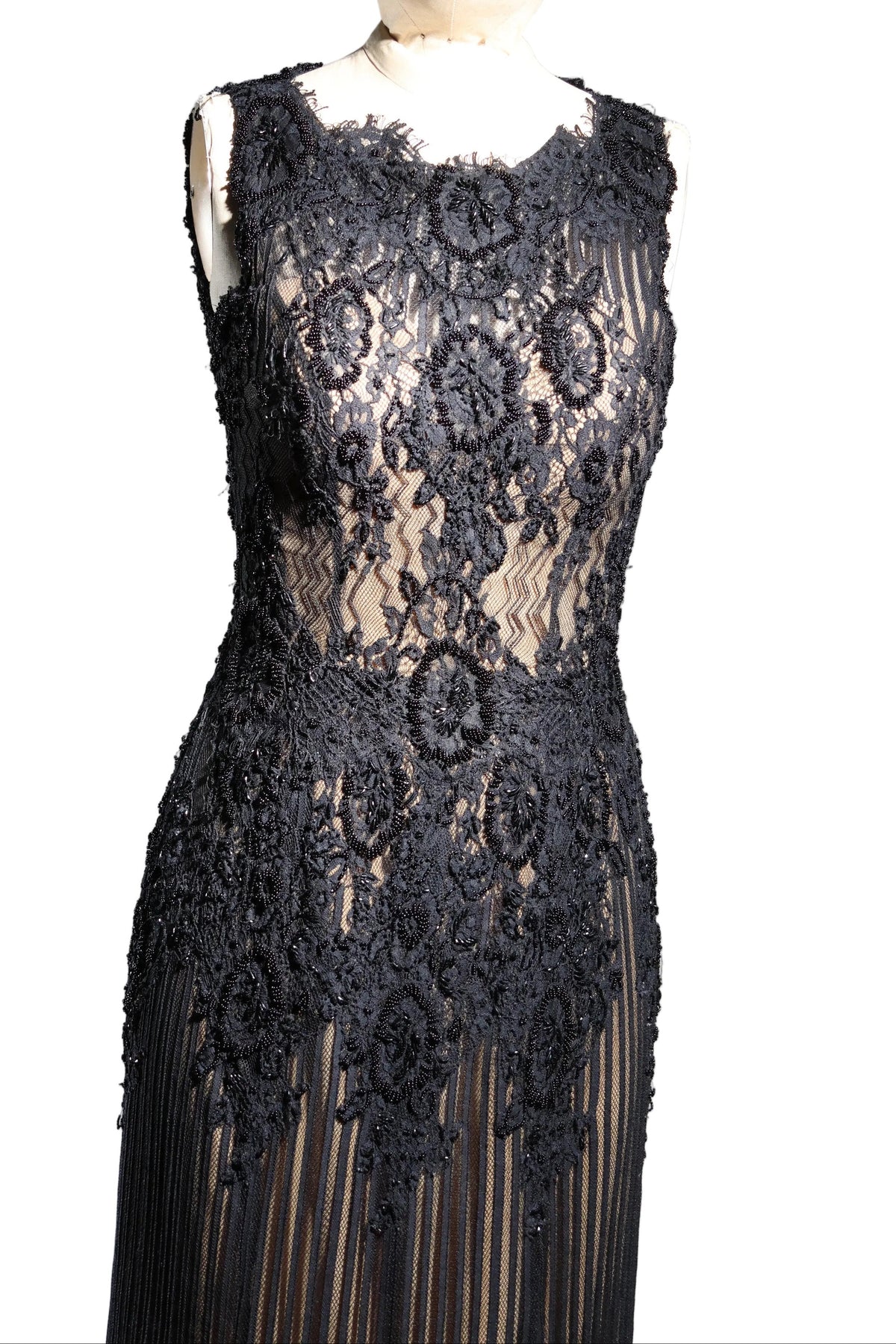 Black lace dress on a mannequin against a gray background