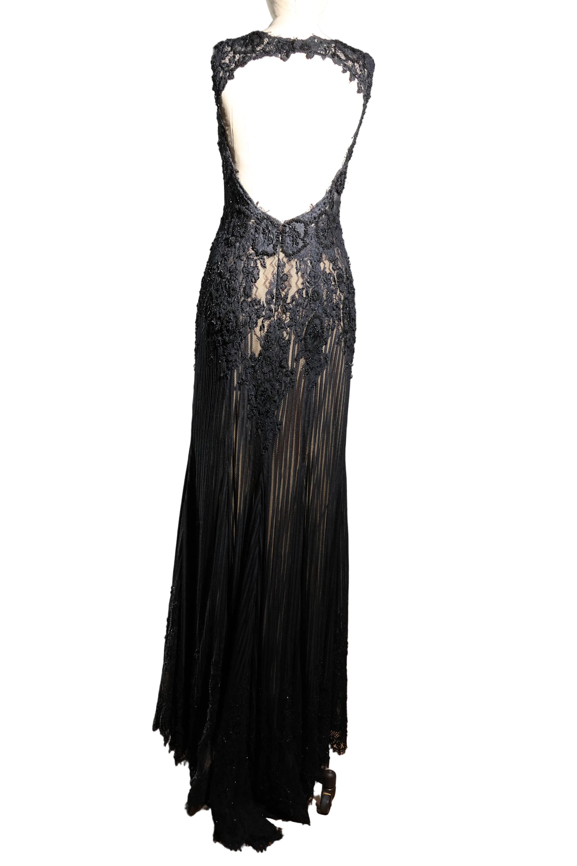Black lace evening gown on a mannequin against a plain background
