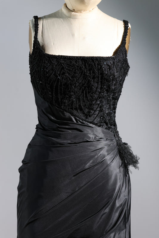 Black evening gown on a mannequin against a gray background