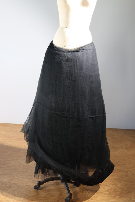 Black skirt on a mannequin against a plain background